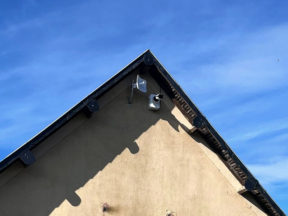 Pignon de bâtiment avec caméra et antenne en pointe